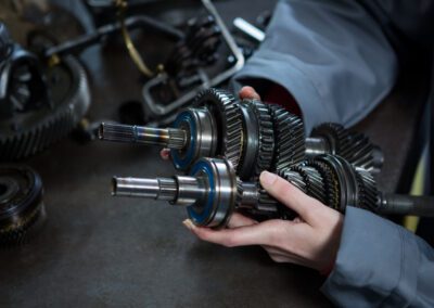 Female mechanic holding spare parts of car